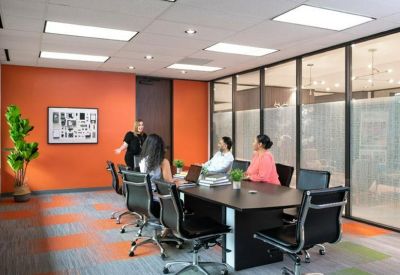 Modern meeting room with an orange feature wall and grey patterned carpet.