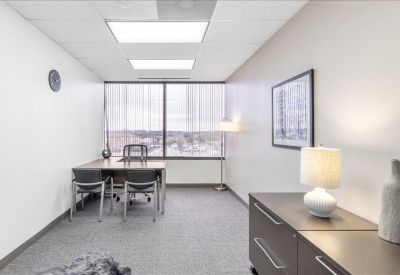 Private office with two guest chairs and large windows.