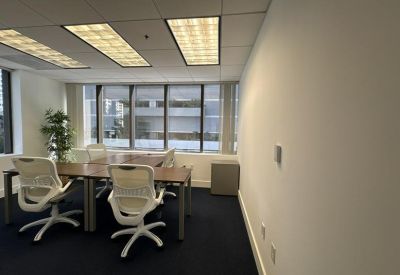 Bright office space featuring two white ergonomic chairs and a shared wooden desk.