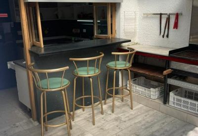 Covered patio featuring a black bar counter and gold-accented stools.