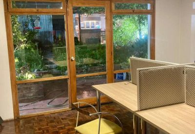 Workspace with parquet flooring and large windows overlooking greenery.