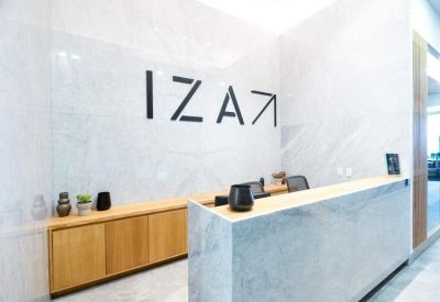 Modern marble reception desk with minimalist black logo on the wall.