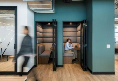 Modern teal-walled acoustic phone booths for private calls.