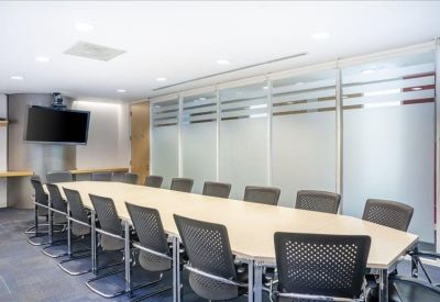 Large professional conference room with a long oval table and frosted glass walls.