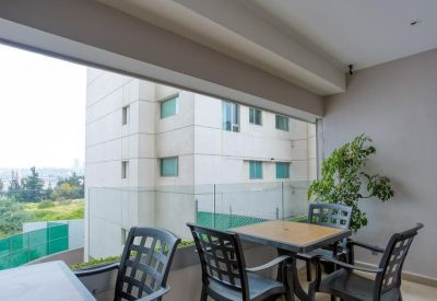 Outdoor balcony terrace with black patio furniture and views of the surrounding neighborhood.