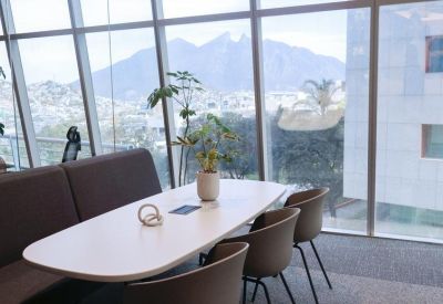 Modern lounge area with an oval table and white chairs overlooking city views.