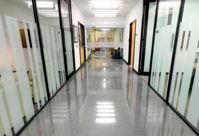 Polished office corridor with frosted glass doors and bright overhead lighting.
