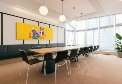 Bright conference room with a long wooden table and vibrant wall art.