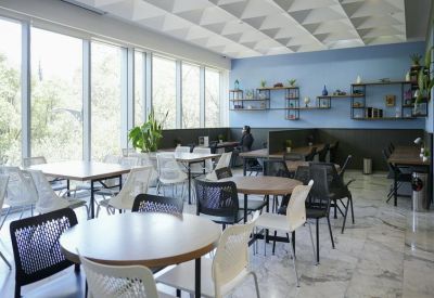 Spacious communal dining and workspace area with blue accent walls.