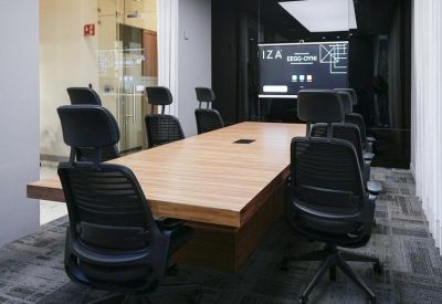 Sleek conference room with a long wood table and screen.