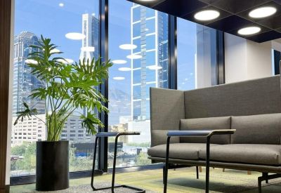 Relaxed lounge area with high-backed sofas and a view of the city skyline.