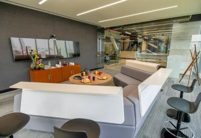 Modern lounge area with a large couch and a flat screen TV.