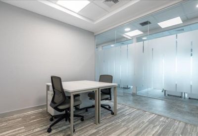 Sleek private office suite with glass partition walls and modern ergonomic chairs.