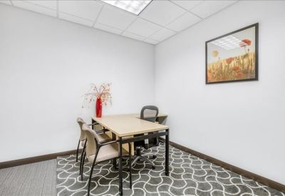 Small three-person office suite with patterned carpet and floral wall art.