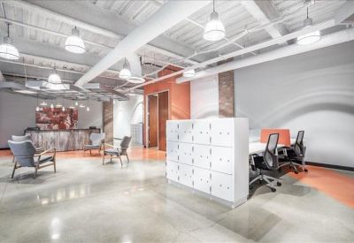 Communal break area featuring white lockers, lounge seating, and an exposed ceiling.