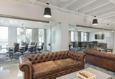 Conference room featuring leather chairs, a long wooden table, and glass walls.