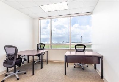 Private office with two dark wood desks and views of the airfield.