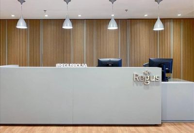 Sleek white reception desk with wood-paneled feature wall and modern pendant lighting.