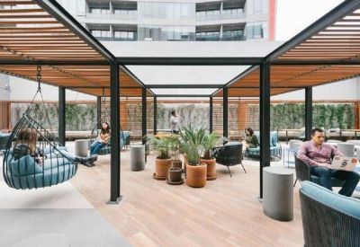 Outdoor communal area with seating, plants, and hanging chair.