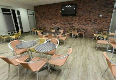 Breakout area with round tables and a brick feature wall.