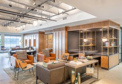 Modern lounge with leather armchairs, a grey sofa, and wood-paneled walls.