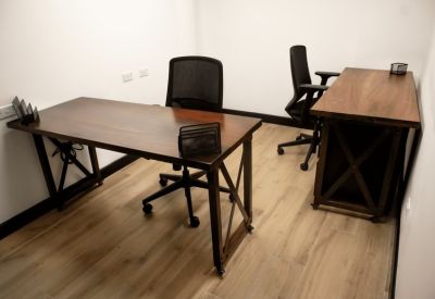 Private office suite with two wooden desks and ergonomic black chairs.