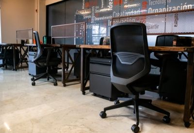 Open-plan coworking space with sleek desks and glass partitions.