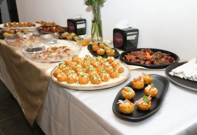 Buffet-style catering spread with various appetizers on a white tablecloth.