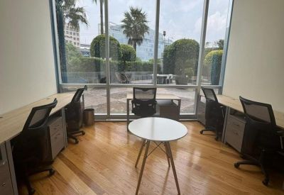 Private office space featuring peripheral desks and a central round collaboration table.