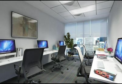 Bright workspace featuring multiple Mac computers and ergonomic chairs.