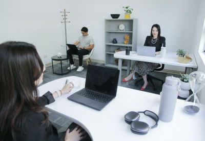 Private office suite with white desks, laptops, and professional staff working.