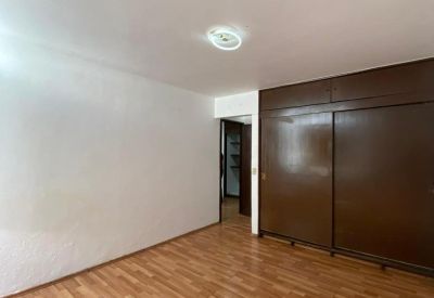 Spacious private office with warm wood laminate flooring and large built-in closets.