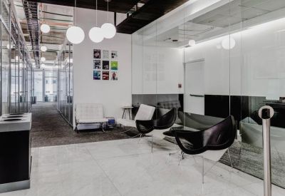 Modern building reception area with stylish black lounge chairs and orb pendant lighting.