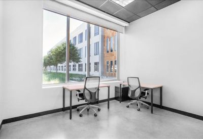 Two-person private office with large window showing trees outside.