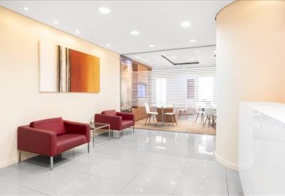 Lounge area featuring red armchairs and warm abstract wall art.