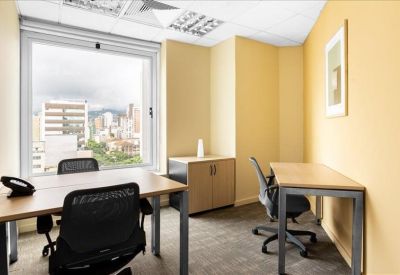 Private office for two with wooden desks and a large window.