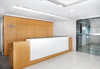 Reception area with a modern wood-paneled wall and white front desk.