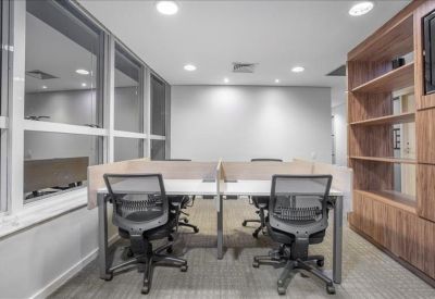 Compact workspace with four desks divided by privacy screens and a large wooden storage unit.