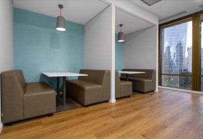 Private coworking booths with brown leather seating and teal accent walls.