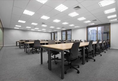 Open-plan office suite with rows of desks and large windows for natural light.