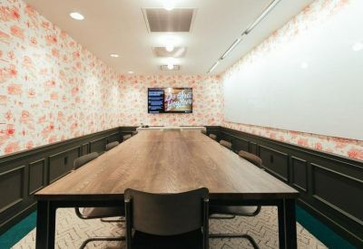 Large conference room featuring a long wooden table and floral patterned wallpaper.