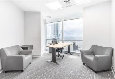 Bright private office suite with grey armchairs and floor-to-ceiling windows.