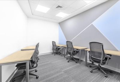 Multi-person office room with a blue and grey geometric feature wall.
