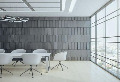 Bright conference room with white chairs and a textured grey feature wall.