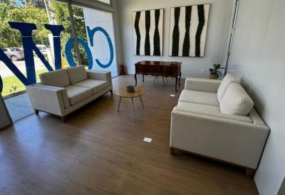 Professional lounge area featuring two cream sofas, a low coffee table, and abstract wall art.