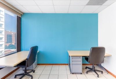 Private office featuring two desks and a bright blue feature wall.