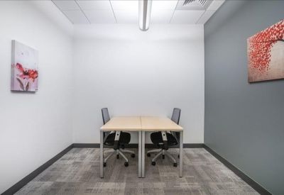 Private two-person internal office with a grey accent wall and red floral artwork.