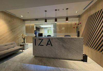 Professional marble reception desk featuring the IZA logo and modern pendant lighting.