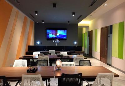 Professional coworking space with long wooden desks and ergonomic mesh chairs.