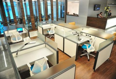 Reception area with wooden wall paneling, white desk, and blue-accented office chairs.
